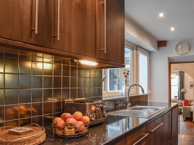 Galley Kitchen with large gas stove, american style fridge and freezer, double oven, microwave, cafetièrs, dishwasher, clothes washer